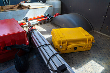 geodetic equipment - a total station and a tripod with a pole put in the cabin of a car standing...