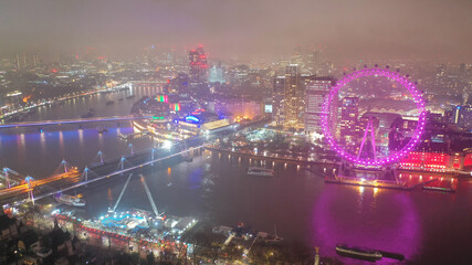 Aerial drone night shot of iconic City of Westminster with houses of Parliament, Big Ben in front of river Thames, London, United Kingdom