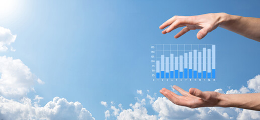Business man holding tablet and showing holographic graphs and stock market statistics gain profits. Concept of growth planning and business strategy. Display of good economy form digital screen.