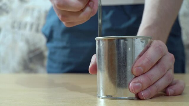 a man opens an iron can