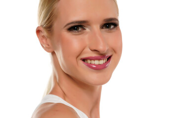 Young smiling blond woman with tied hair and makeup on a white