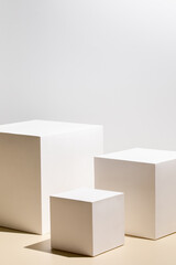 Abstract minimal scene - empty stage with three white rectangle podiums on beige background....