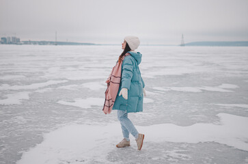a beautiful girl walks on a frozen lake