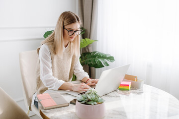 Young business  work from home and writes on laptop 