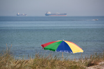 Am Strand unter dem Sonnenschrim