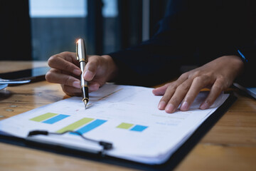 Business woman hand holding pen using laptop with bank savings account application, account or saving money or insurance concept.