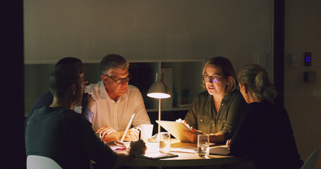Fototapeta na wymiar Late nights are a part of the job. Cropped shot of a group of businesspeople working together around a table in their office.