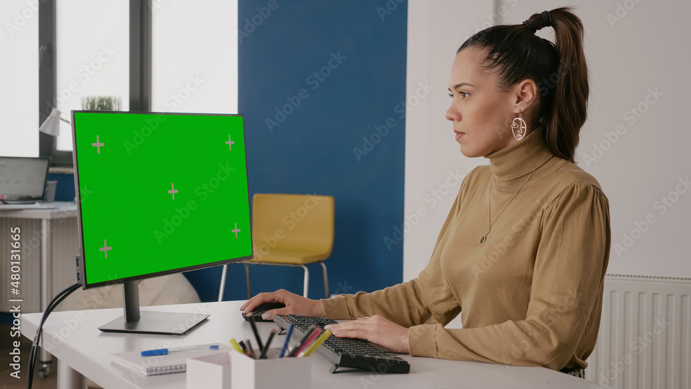 Poster person looking at green screen on computer display in office, working with isolated mock up template