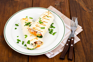 Thin lavash with vegetables and chicken on plate, shawarma. Studio Photo