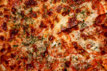 Obraz na płótnie Canvas The background of the surface of a delicious pizza with cheese and dill
