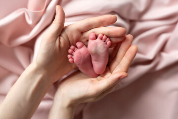 Newborn feet in mother's hands