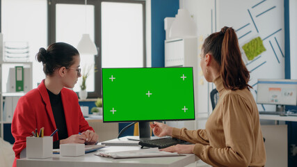 People doing teamwork with green screen on monitor. Women coworkers using computer display with...