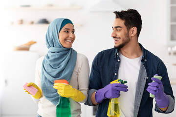 Positive muslim couple cleaning their new apartment