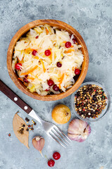 Sauerkraut with red cranberries in wooden bowl. Studio Photo