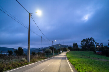 Fototapeta na wymiar Illuminated rural road in the cloudy evening, central Portugal