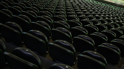 Empty stadium tribune with green seats.