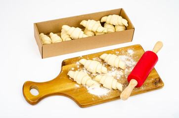 Frozen raw croissants in box on white background. Studio Photo