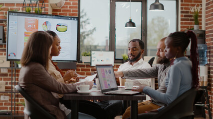 Business people working together to plan marketing project and strategy, using analysis documents to design data charts for financial presentation. Colleagues doing teamwork at office job.