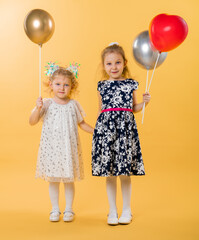 Children with balloons on a yellow background. Birthday, holiday for small