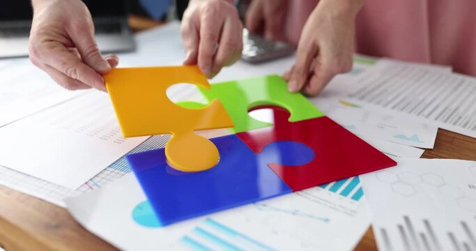 Team of business people add up multicolored puzzles