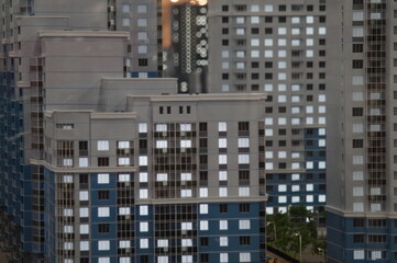 Fototapeta na wymiar Full-color horizontal photo. Parts of facades of typical high-rise residential buildings. Top view. The background is blurred.