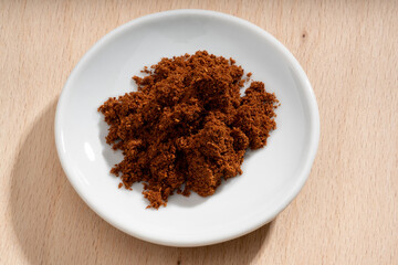Detailed and large close up shot of powdered star anise on a small plate