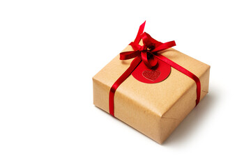 Elegant design of present gift box wrapped in brown craft paper with red ribbon