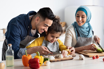 Young Arab Father Showing How To Chop Mushrooms To His Little Daughter