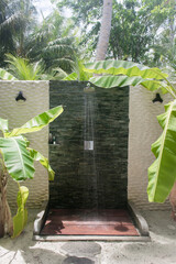 An amazing outdoor shower near the ocean  in a resort hotel on an exotic tropical island.  Maldives. A heavenly place to relax. Tourism, travel. 