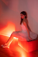 Ballerina with long legs posing in red light