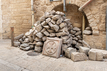 Broken tiles with Coptic cross relief in a pile of construction debris next to the Church of...