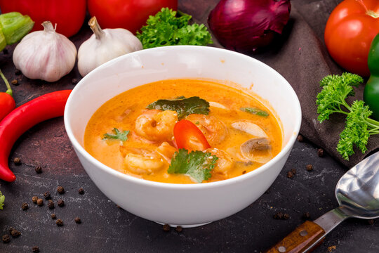 Tom Yam soup with shrimps on white bowl on dark table