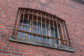Vergittertes Fenster in einem alten Backsteingebäude