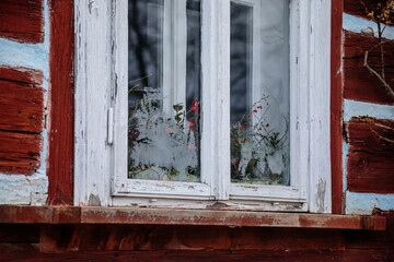 Fototapeta na wymiar Kourim, Czech Republic, 26 December 2021: vintage windows with frosty pattern on glass in log wall of old wooden house, Frosty snowy winter, Christmas and New Year, village rural lifestyle background