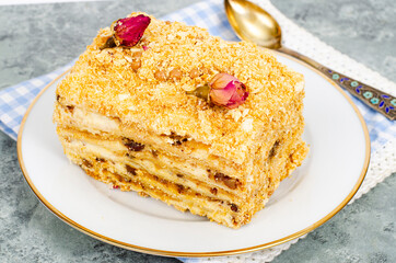 Piece of homemade puff pastry cake with cream on white plate. Studio Photo