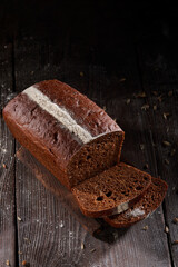 Loaf of rye bread on a dark wooden background