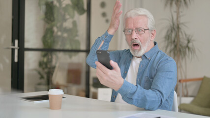 Senior Old Man Reacting to Loss on Smartphone in Office