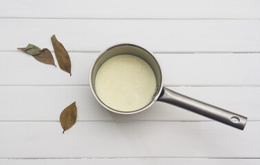 Sauce bechamel on a white table.