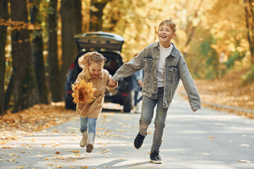 Obraz premium Weekend activities. Happy family is in the park at autumn time together