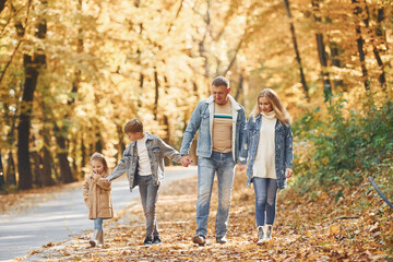 Cheerful people. Happy family is in the park at autumn time together