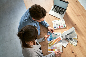 Top view of caucasian couple choosing colors for new house
