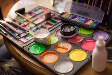 Paints and brushes, set for make-up artist, body art, artist. Variety of colors and shades. Yellow, green, orange, pink, white