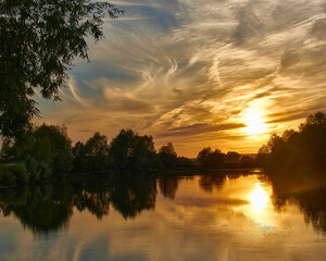 Beautiful sunset on the river bank. Sunset river landscape. River at sunset. Red sunset river