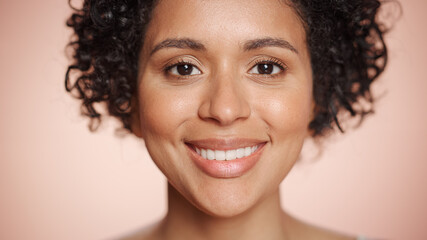 Female Beauty Portrait. Beautiful Black Woman with Afro Hair Posing, Her Skin is Natural and Healthy. Wellness and Skincare Concept on Soft Isolated Background. Close Up.