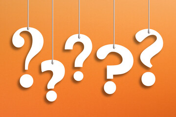 White question marks suspended by ropes on orange background