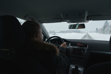 Woman driving a car in winter time.