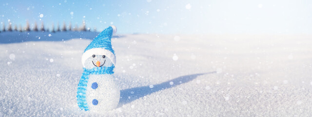 Winter snow snowman background panoramic banner panorama - Little cute Snowman sits on snow in snowy black forest landscape with snowflakes blue sky and sunshine.