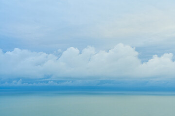 A smooth line of thick clouds on the horizon above the sea
