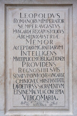 Latin inscription in black uppercase letters engraved in stone, 17th century dedication to German Roman emperor in Bratislava