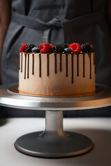 Vegetarian cake with streaks of chocolate decorated with berries.